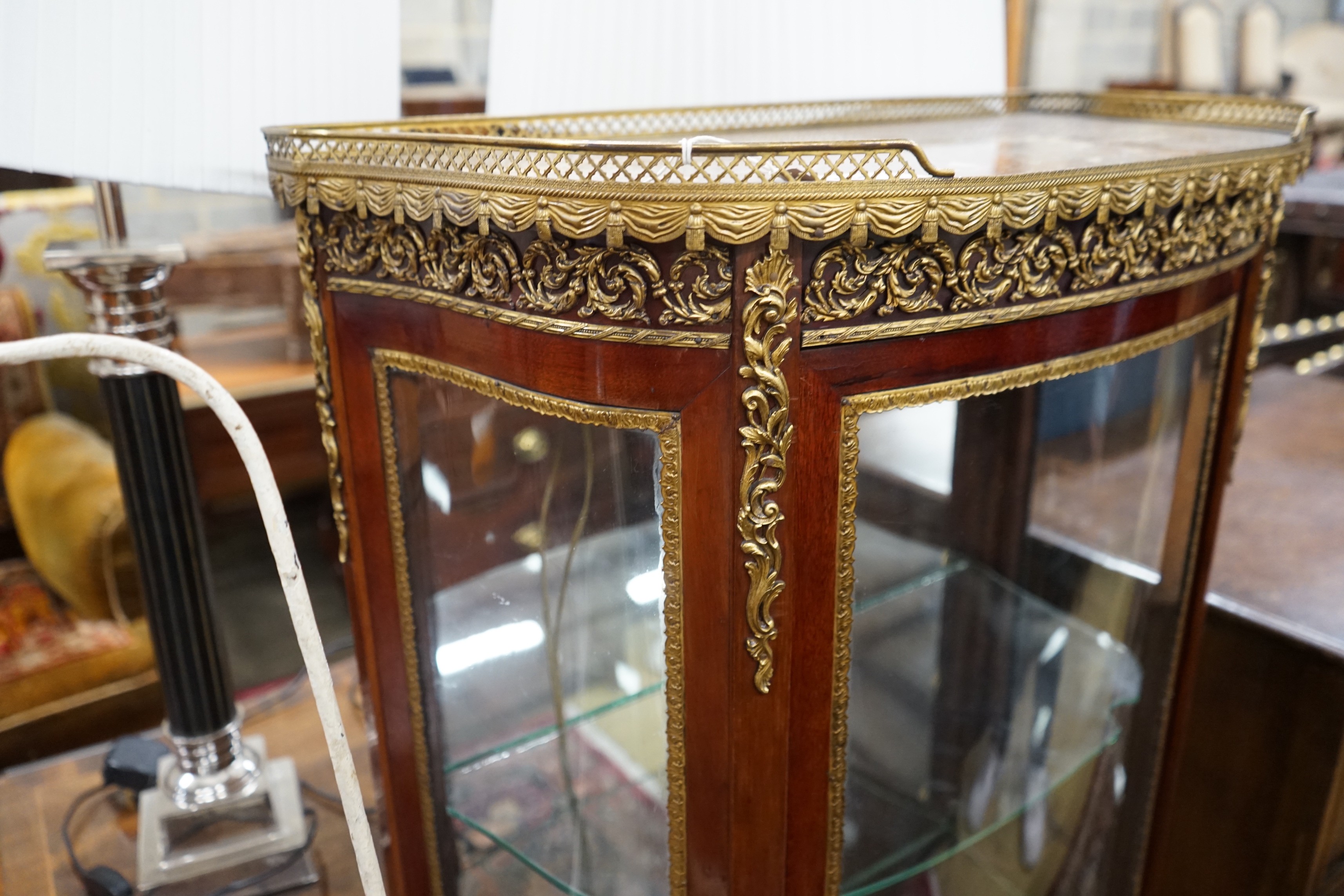 A Louis XV style gilt metal mounted marble topped bow fronted vitrine, width 67cm, depth 34cm, height 139cm